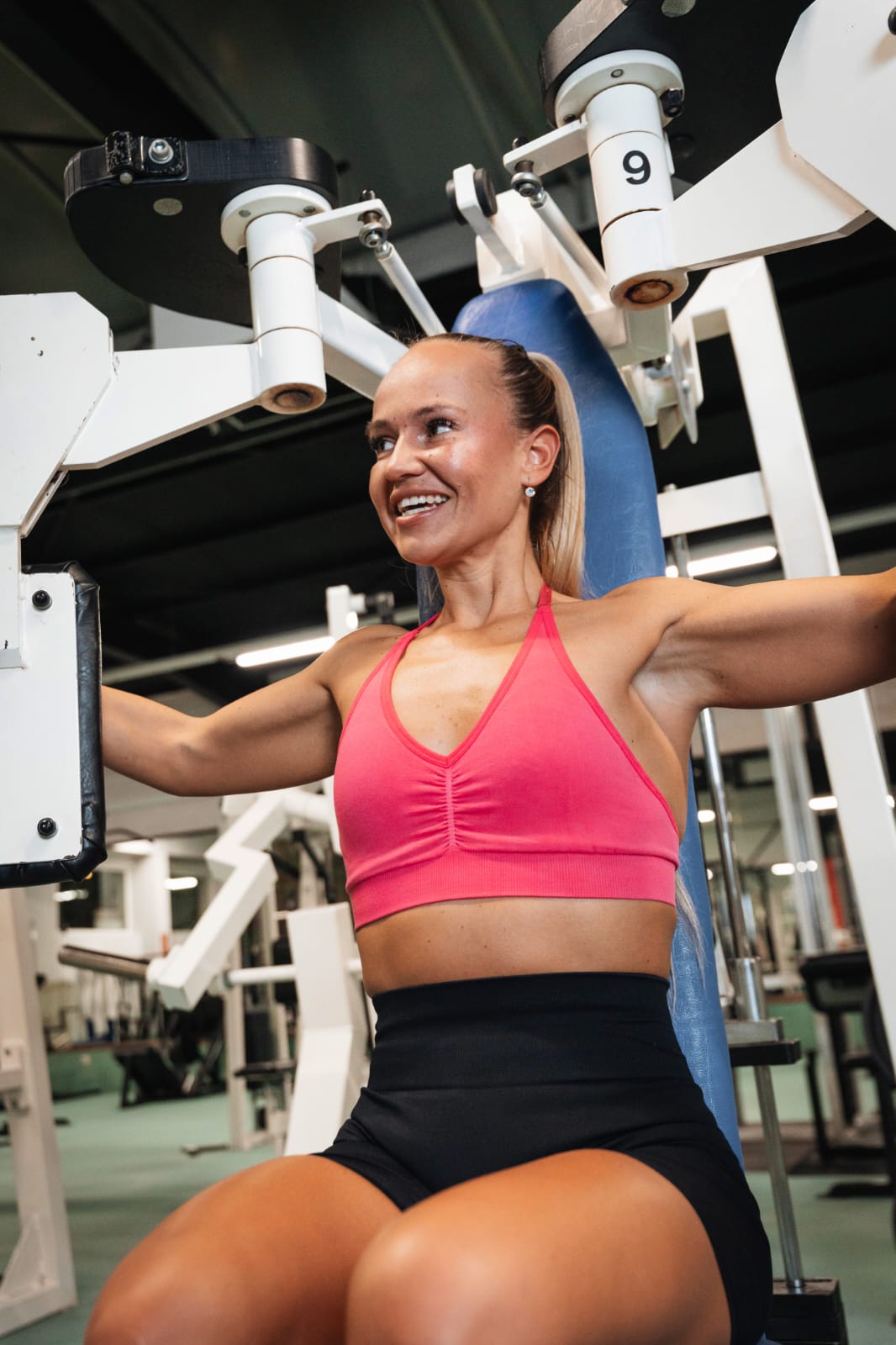 Frau trainiert am Fitnessgerät in einem modernen Fitnessstudio.